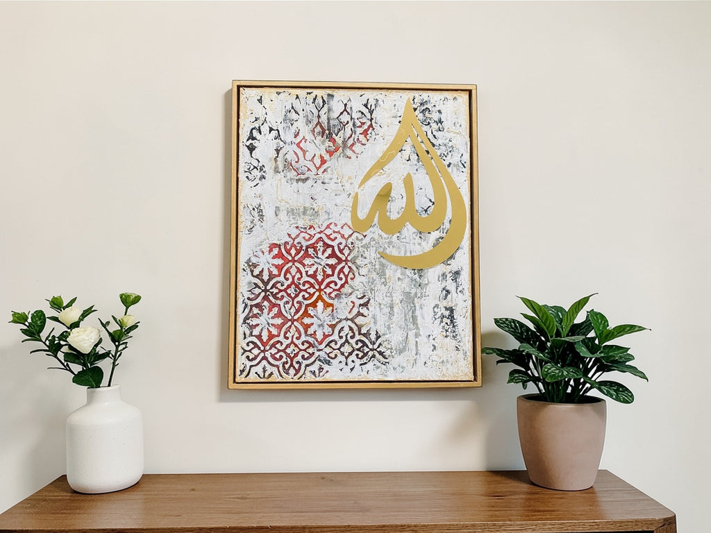 Decorative wall art with Arabic calligraphy on a wooden shelf with plants and a vase.