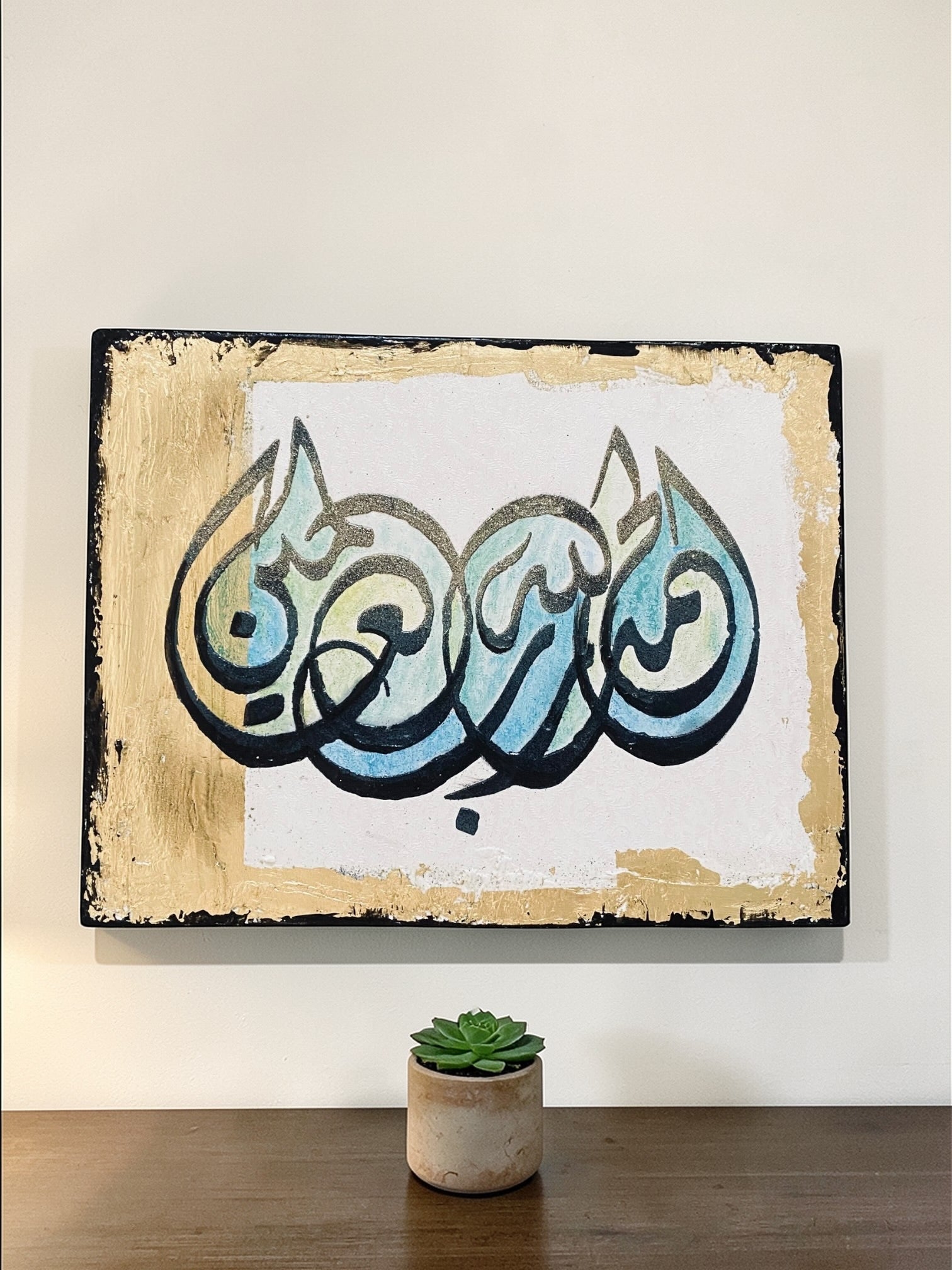 Decorative wall art with stylized text in a rustic frame on a white wall.