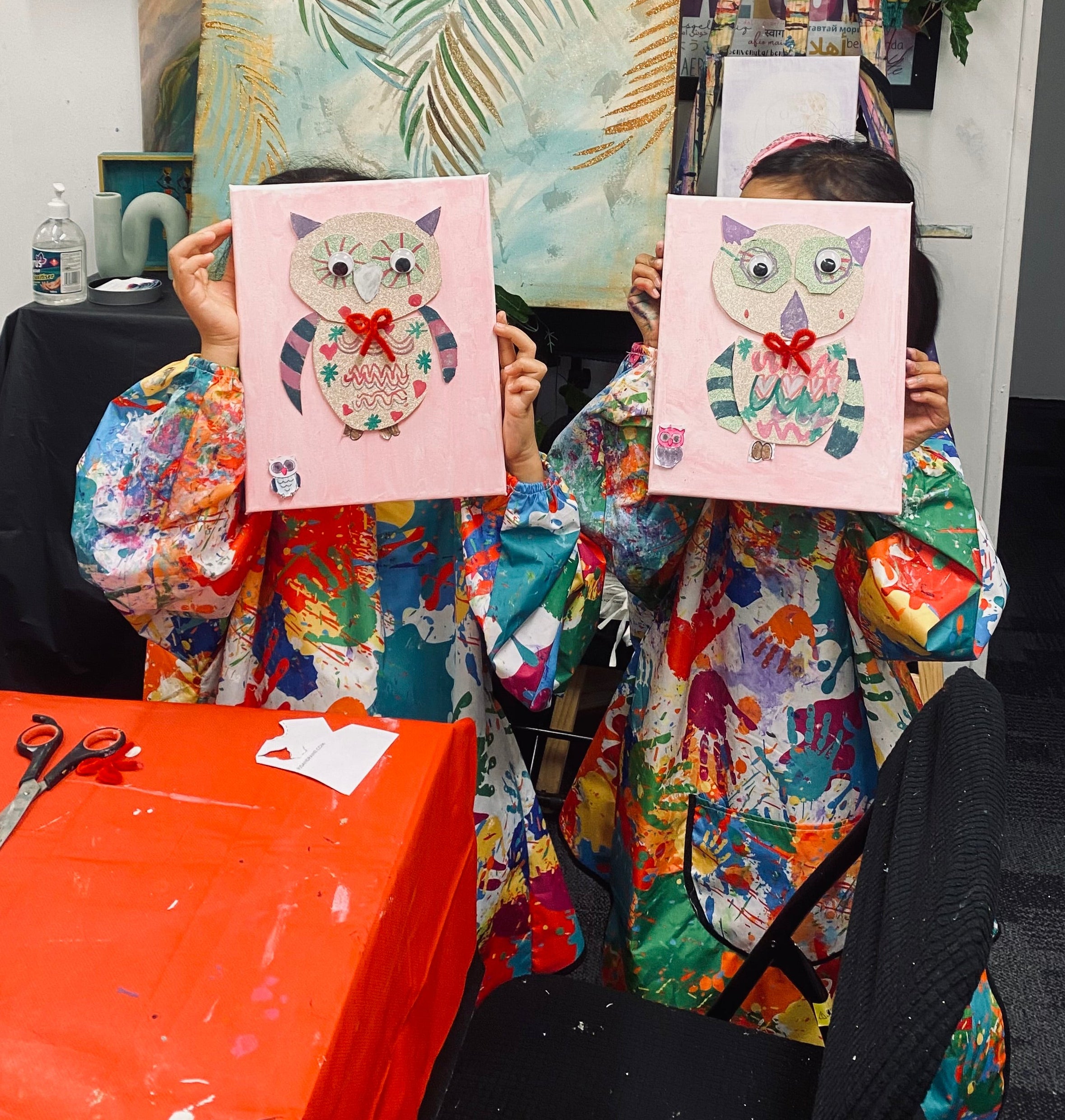 Children holing their paintings done in Designed By Sue Studio 